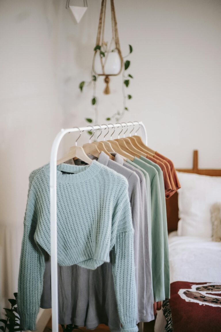 Chic bedroom interior featuring a stylish clothing rack with cozy sweaters in earthy tones.