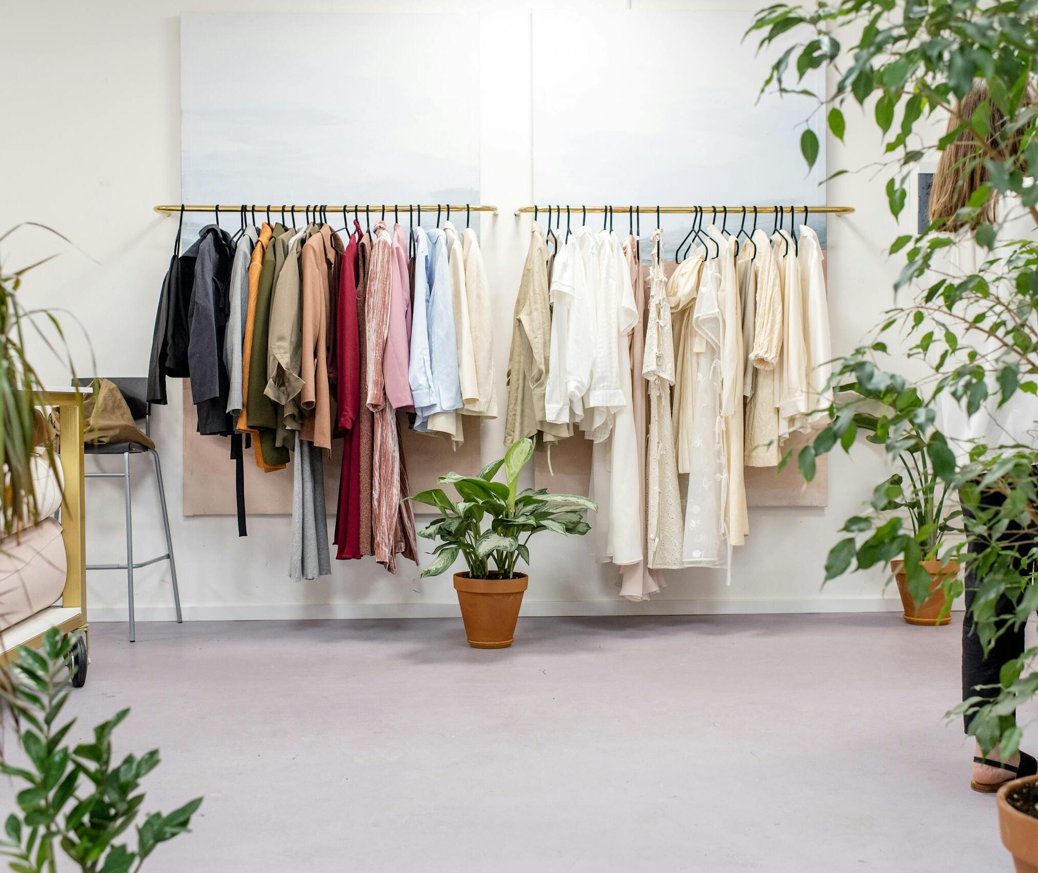 Chic fashion boutique showcasing vibrant clothing collection with lush indoor plants.