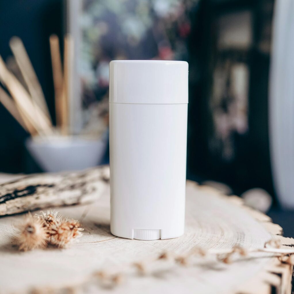 Close-up of a white deodorant container on a textured wooden surface. Natural and eco-friendly vibe.