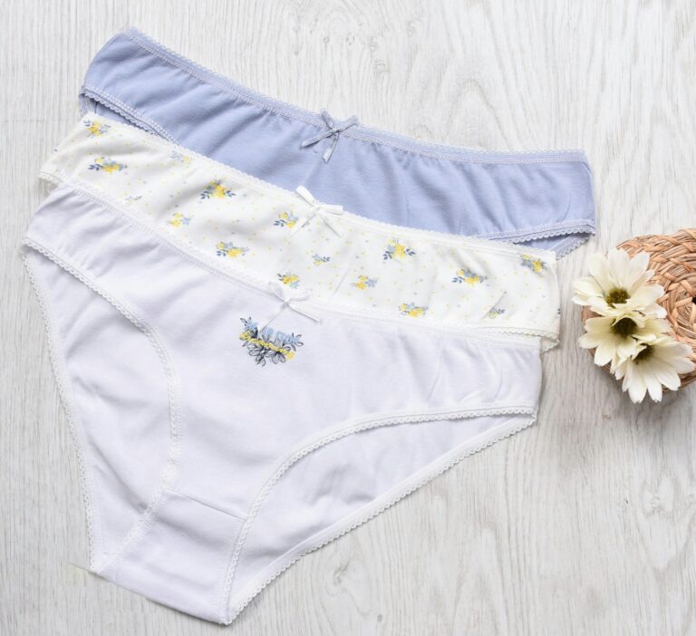 Three sets of elegant women's cotton panties displayed with floral decorations.