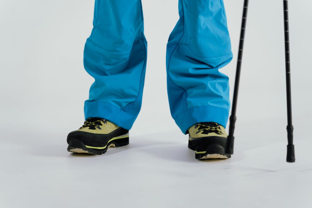 Close-up of winter boots and trekking poles on a snowy surface, ready for adventure.