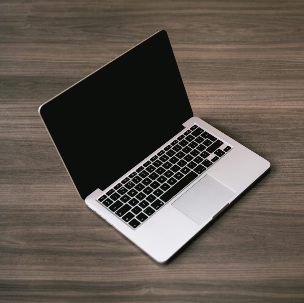 Sleek open laptop placed on a polished wooden floor, showcasing modern technology design.