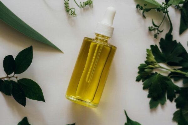 A dropper bottle of essential oil placed amidst vibrant greenery, ideal for aromatherapy concepts.