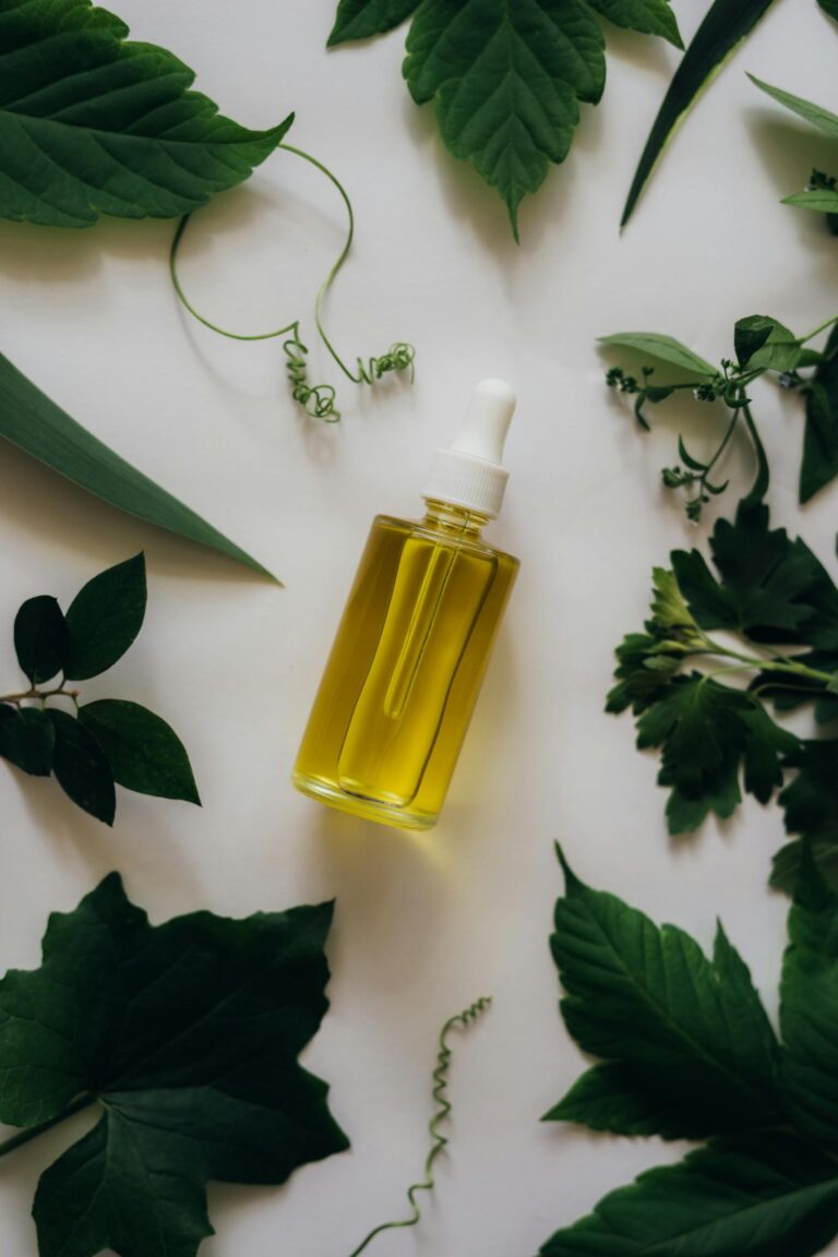 A dropper bottle of essential oil placed amidst vibrant greenery, ideal for aromatherapy concepts.