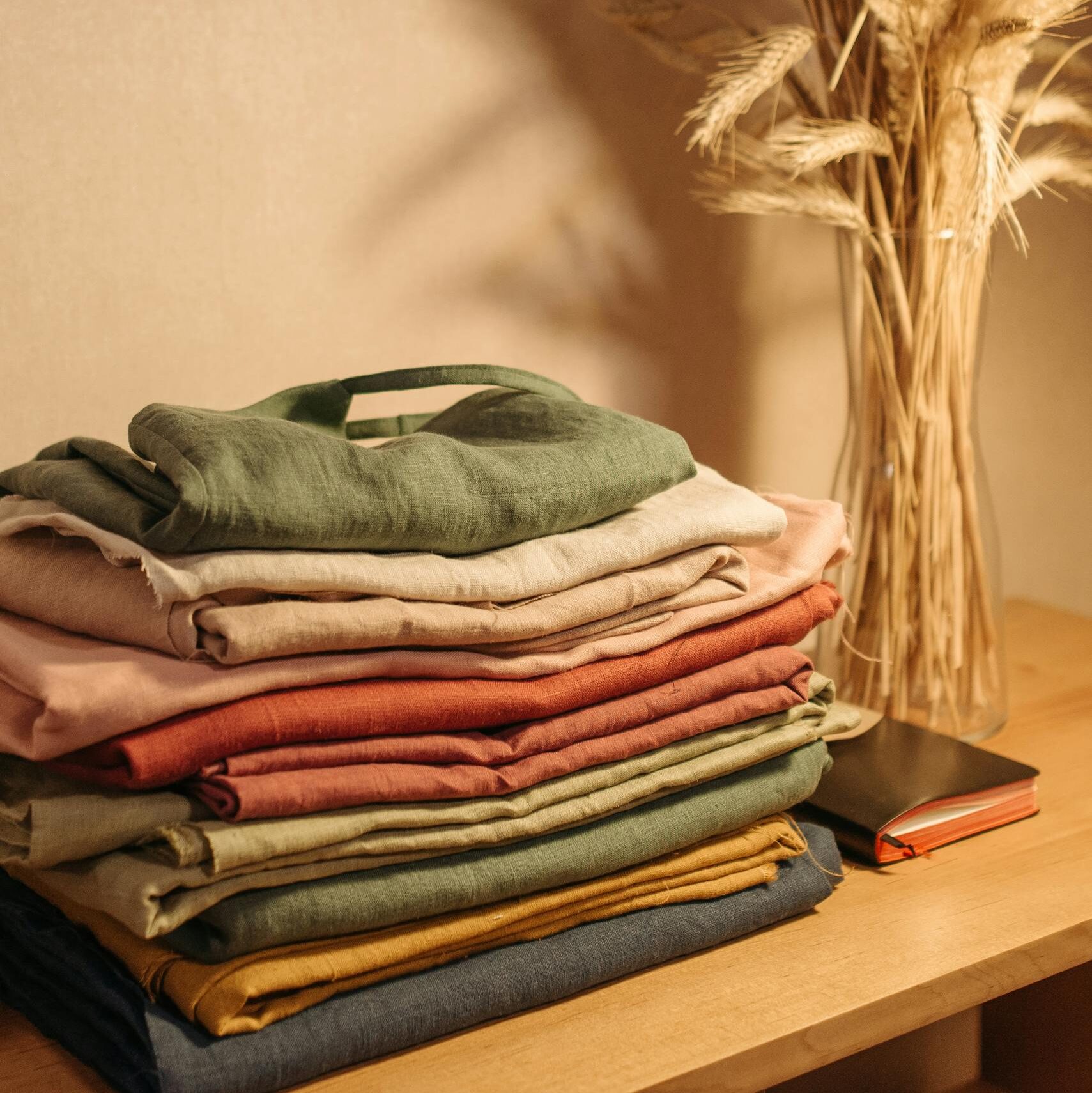 Aesthetic arrangement of linen clothes and dried flowers on a wooden table.
