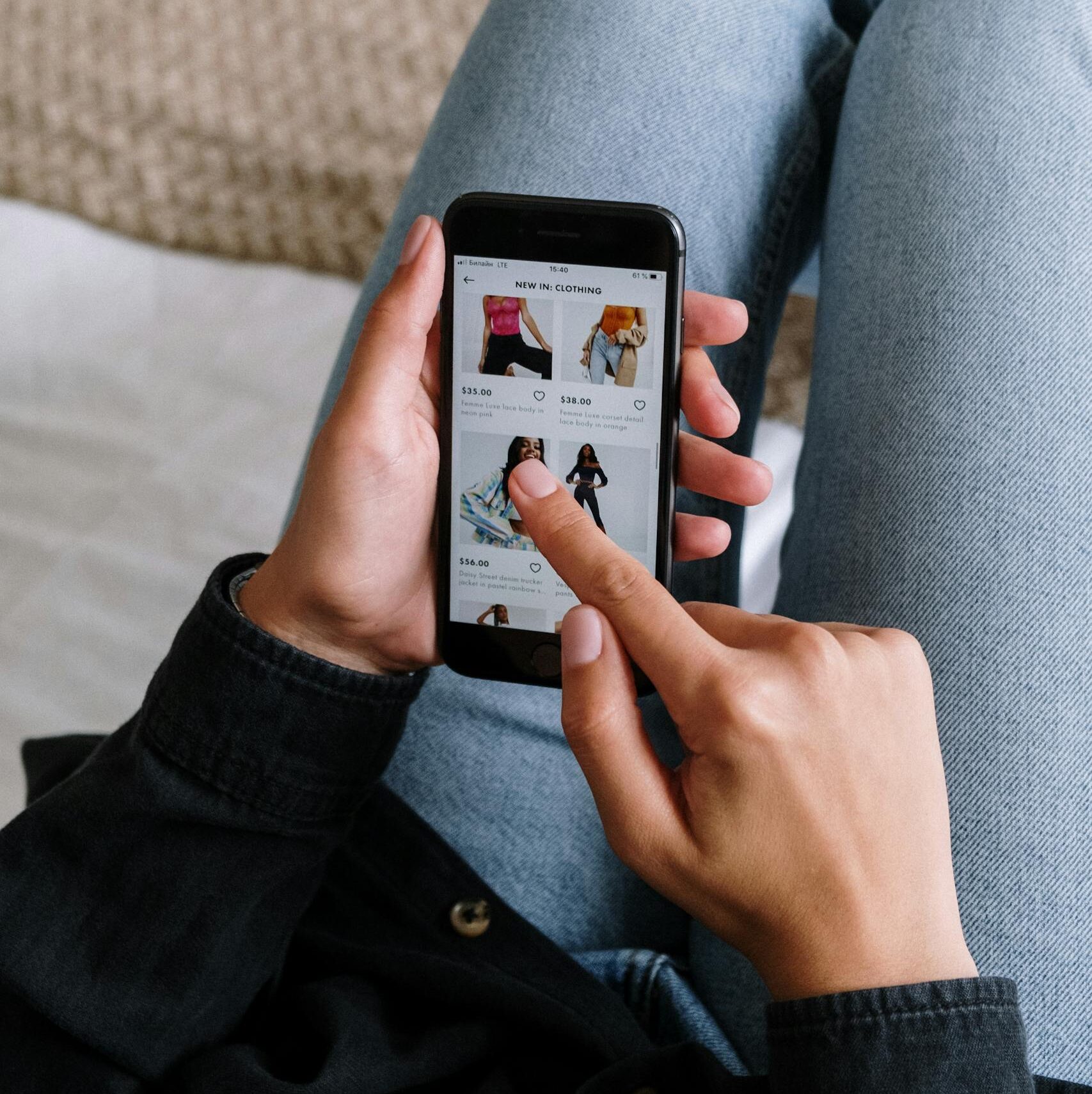 Close-up of a woman shopping online on a smartphone while relaxing at home.