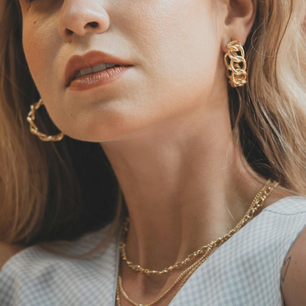 Close-up portrait of a woman with gold jewelry, capturing elegance and style.