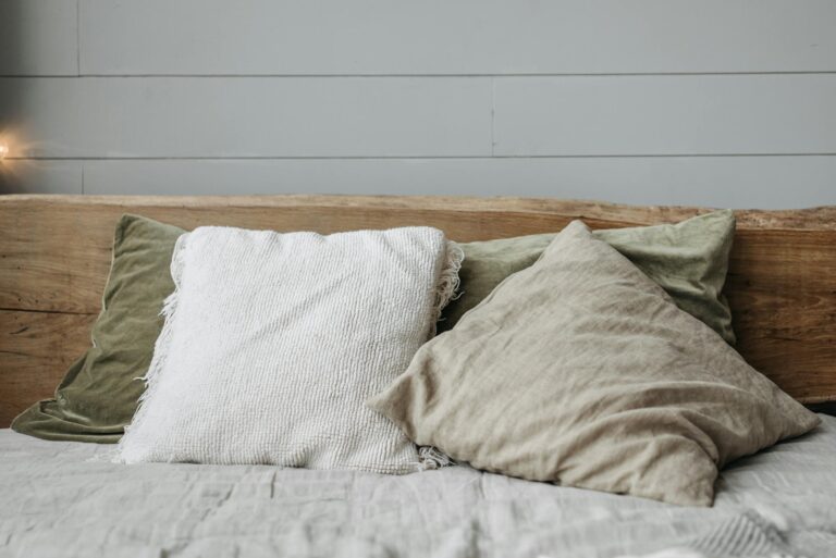 Relaxing bed setting with rustic wooden headboard and cushions.