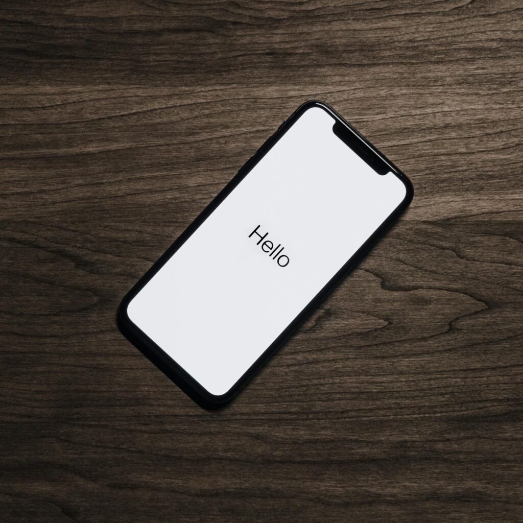 A smartphone displaying 'Hello' on a wooden surface, showcasing modern technology.