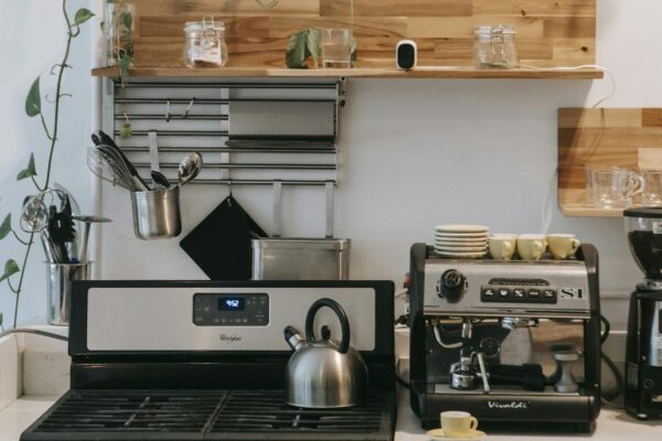 Interior of contemporary light kitchen with stove and various appliances on modern kitchen unit