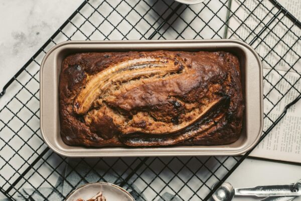 Top view of a delicious homemade banana bread fresh from the oven placed on a cooling rack. Enjoy the warm and inviting aroma.
