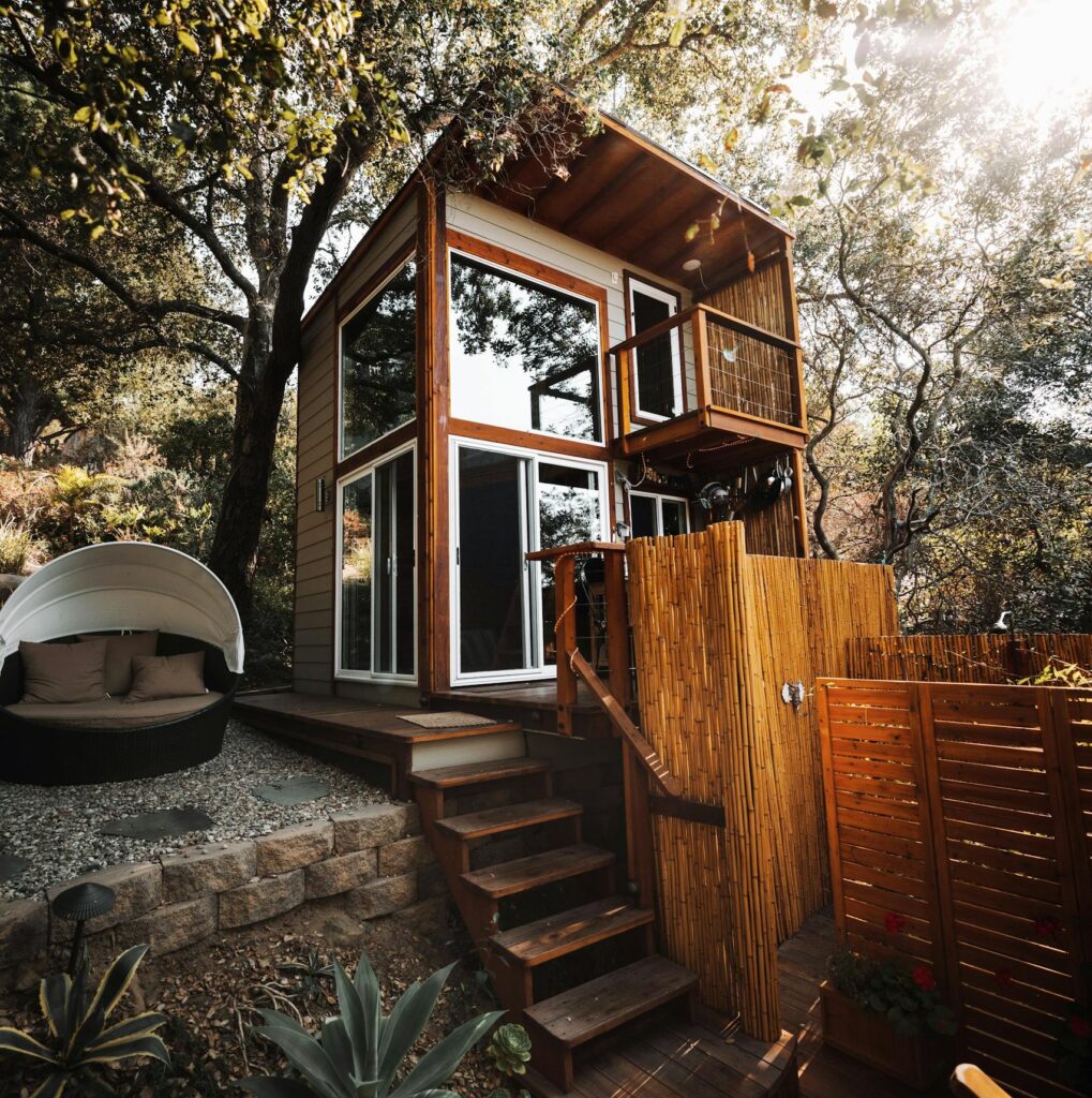A stylish wooden cabin amidst green foliage, ideal for a serene getaway.