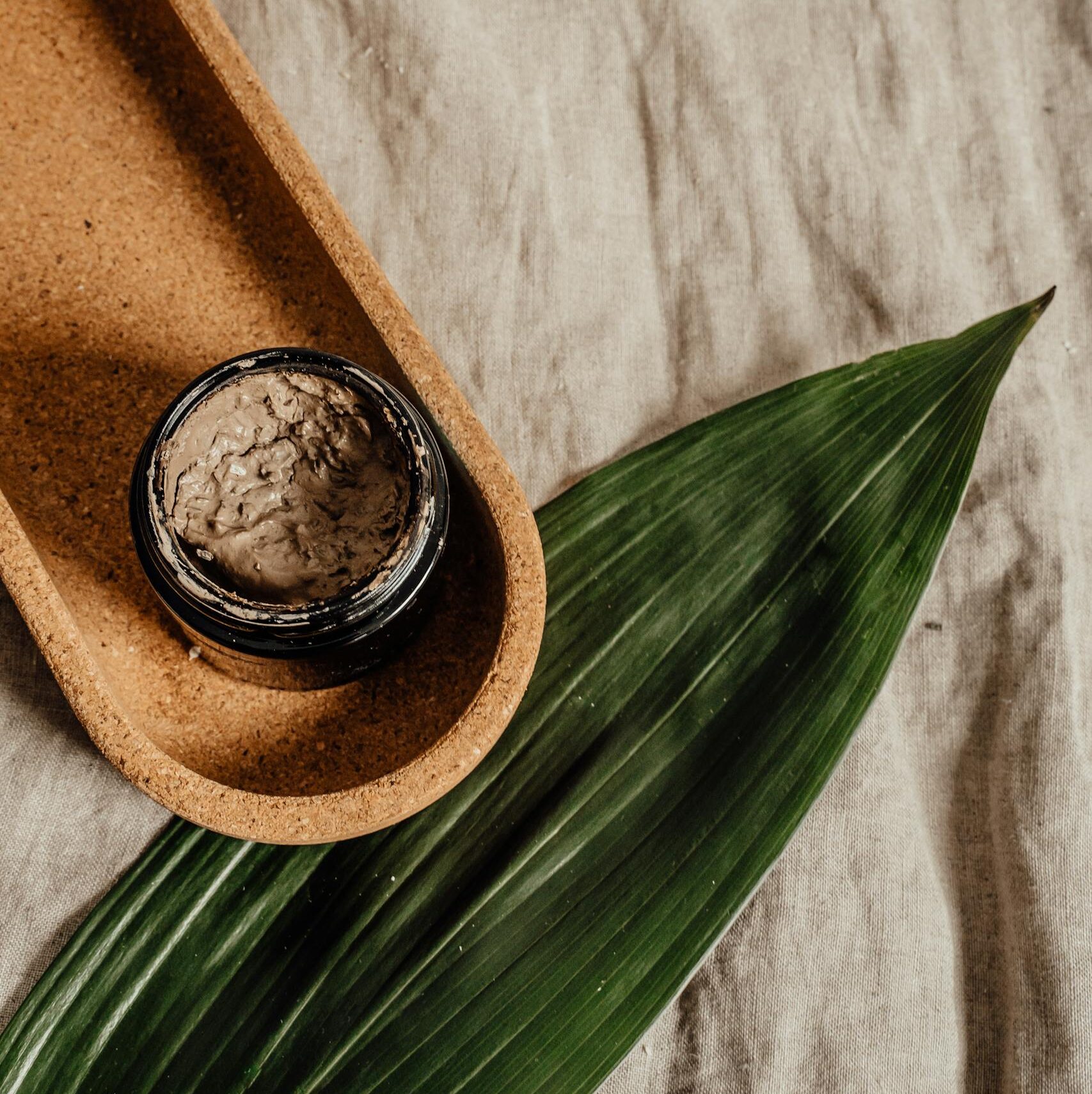 Minimalist flat lay of a skincare jar with natural textures, perfect for eco-friendly beauty brands.