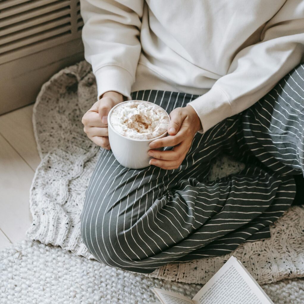 Relaxing at home with a hot cocoa and a book, enjoying a peaceful weekend indoors.