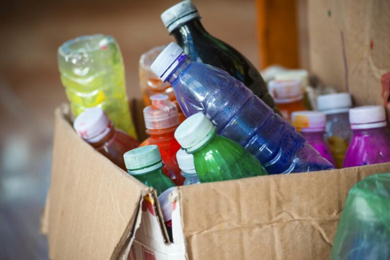 Vibrant array of plastic bottles stored in a cardboard box. Perfect recycling concept.