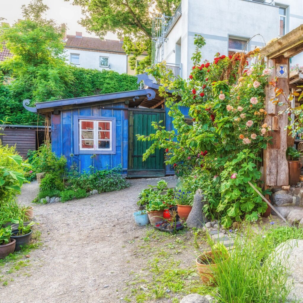 A picturesque garden with colorful flowers and rustic architecture in Stralsund, Germany.