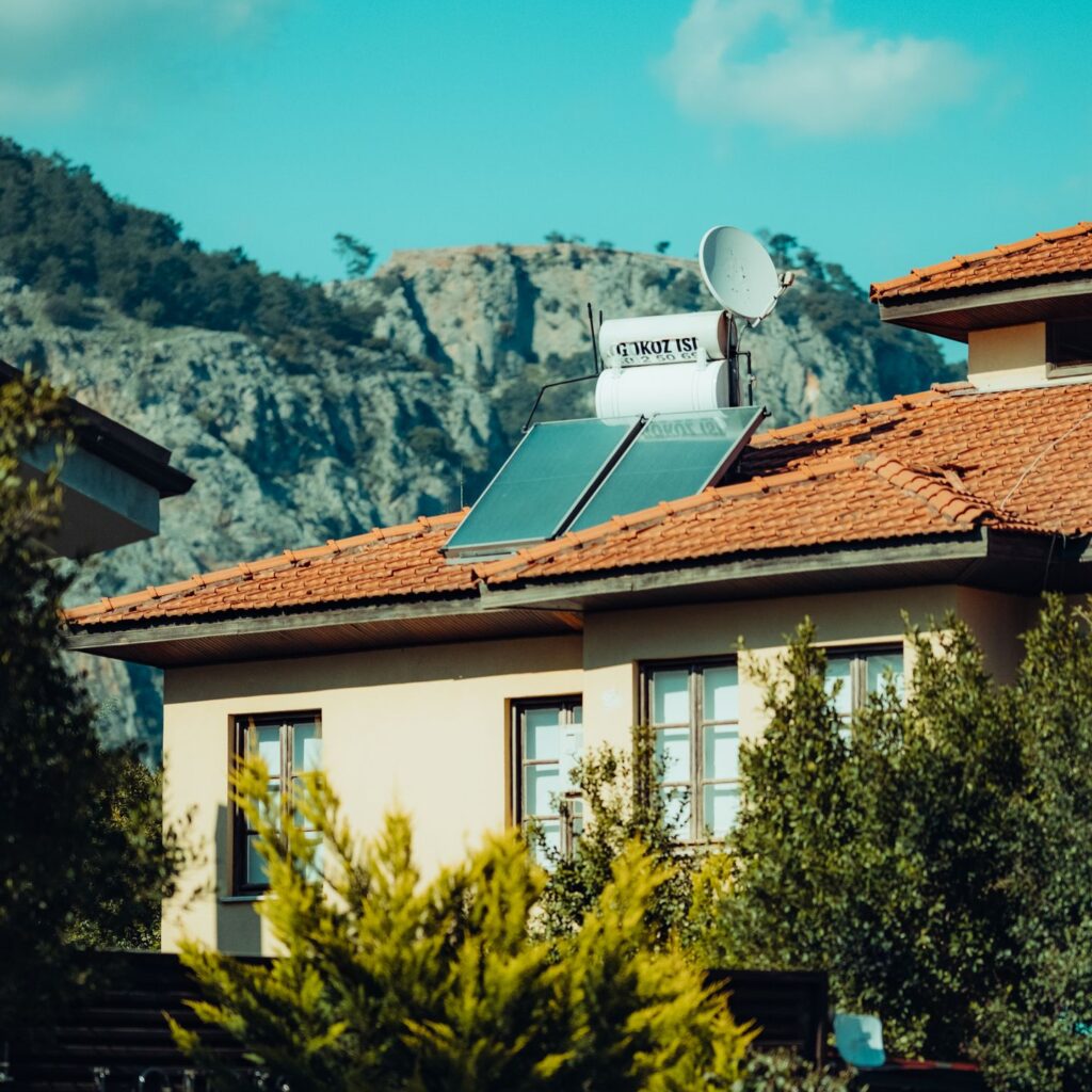 A picturesque urban house with solar panels and mountain view in the background.