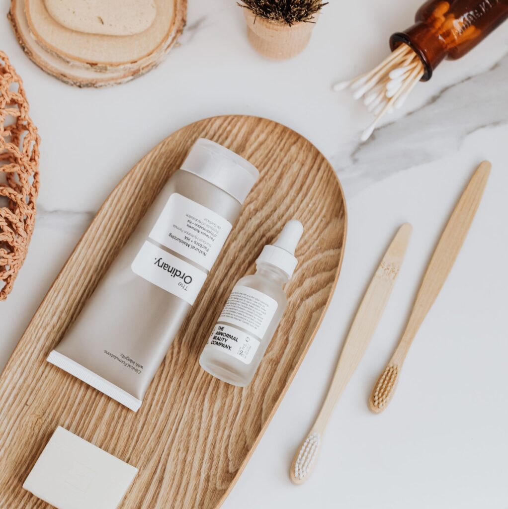 Modern minimalist flat lay featuring sustainable skincare and oral care items on wooden tray.